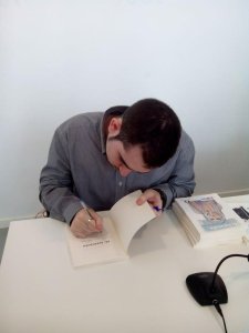 Fernando López García, literato español firmando ejemplares de su última publicación : Mi Tormenta